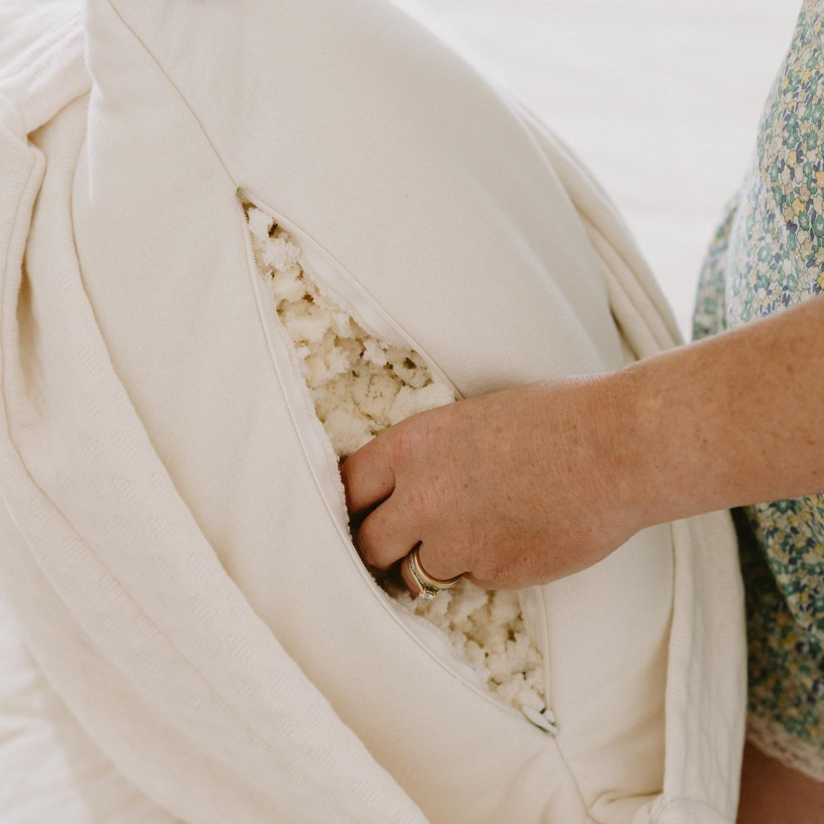 Kakun Organic Luxury Latex Pillow - hands reaching into unzipped pillow, showing shredded latex fill inside