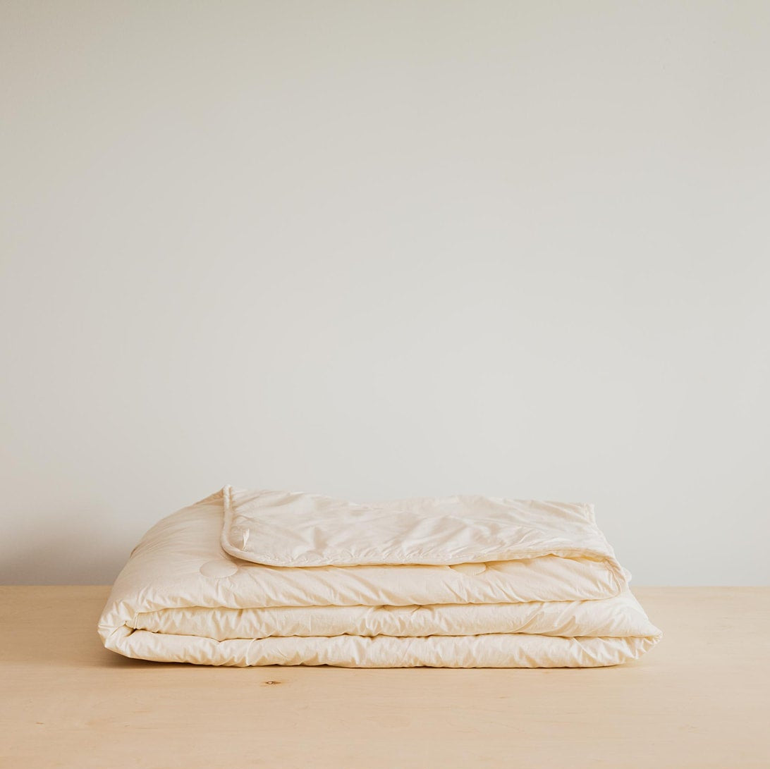Kakun Organic Wool Comforter - folded on wood surface