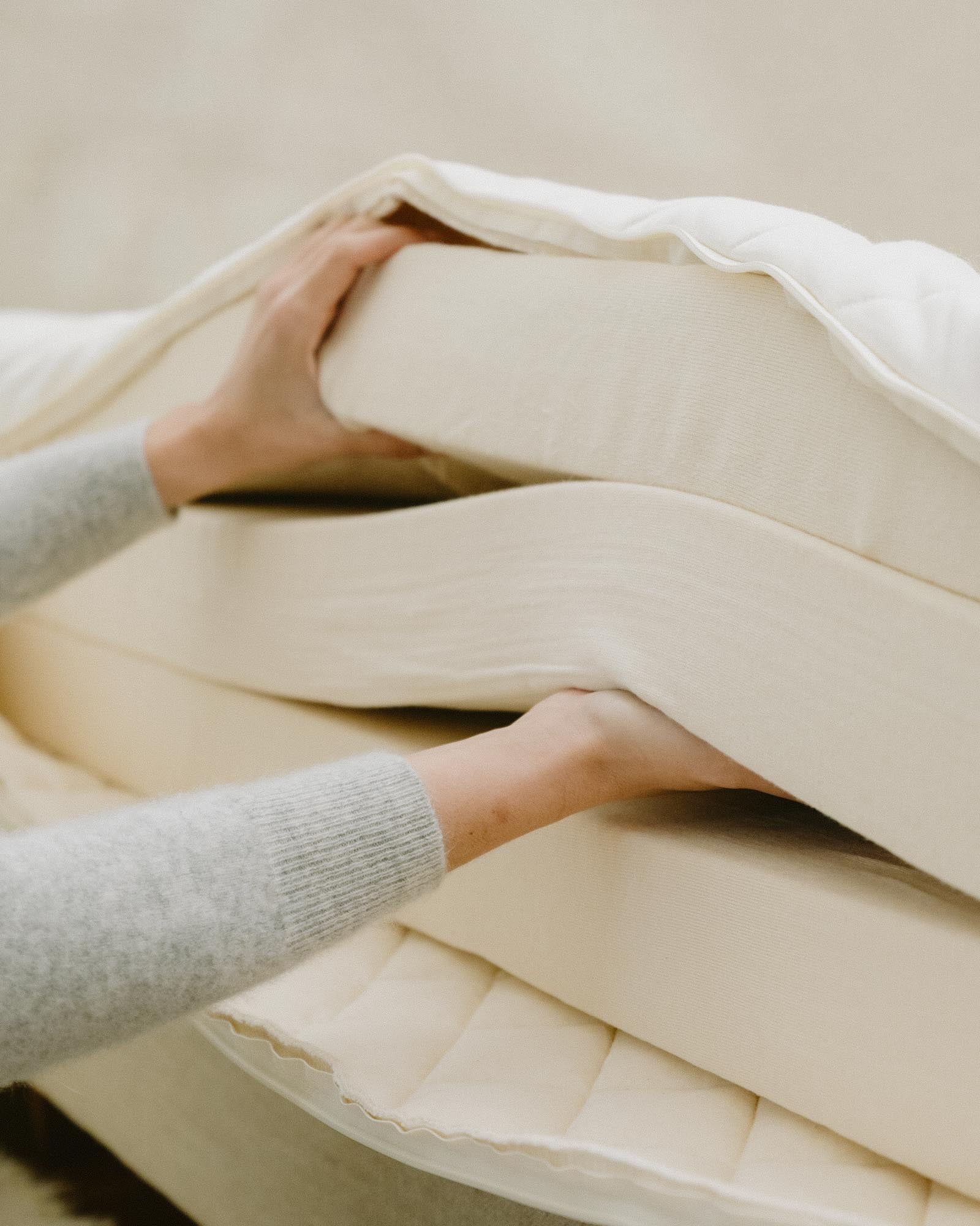 Kakun Ten Organic Latex Mattress - casing open with model separating layers by hand