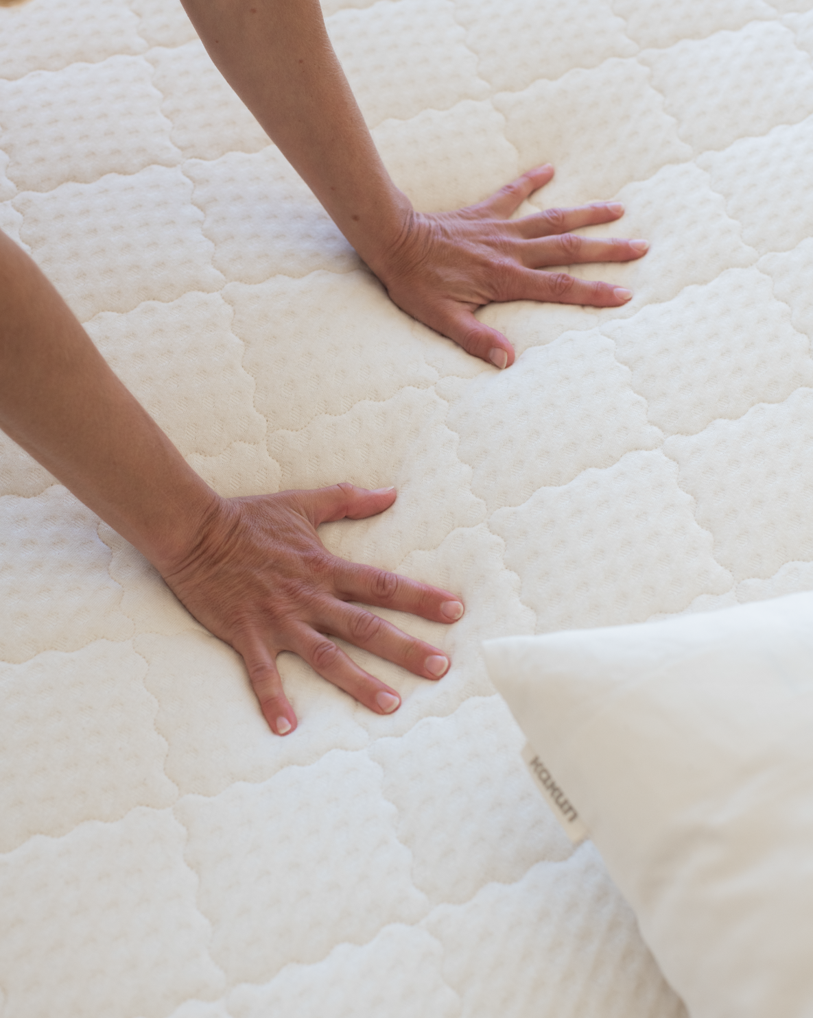 Kakun Twelve Organic Latex Mattress - model pressing down on mattress with hands