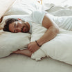Man sleeping peacefully on a bed with luxury body bedding