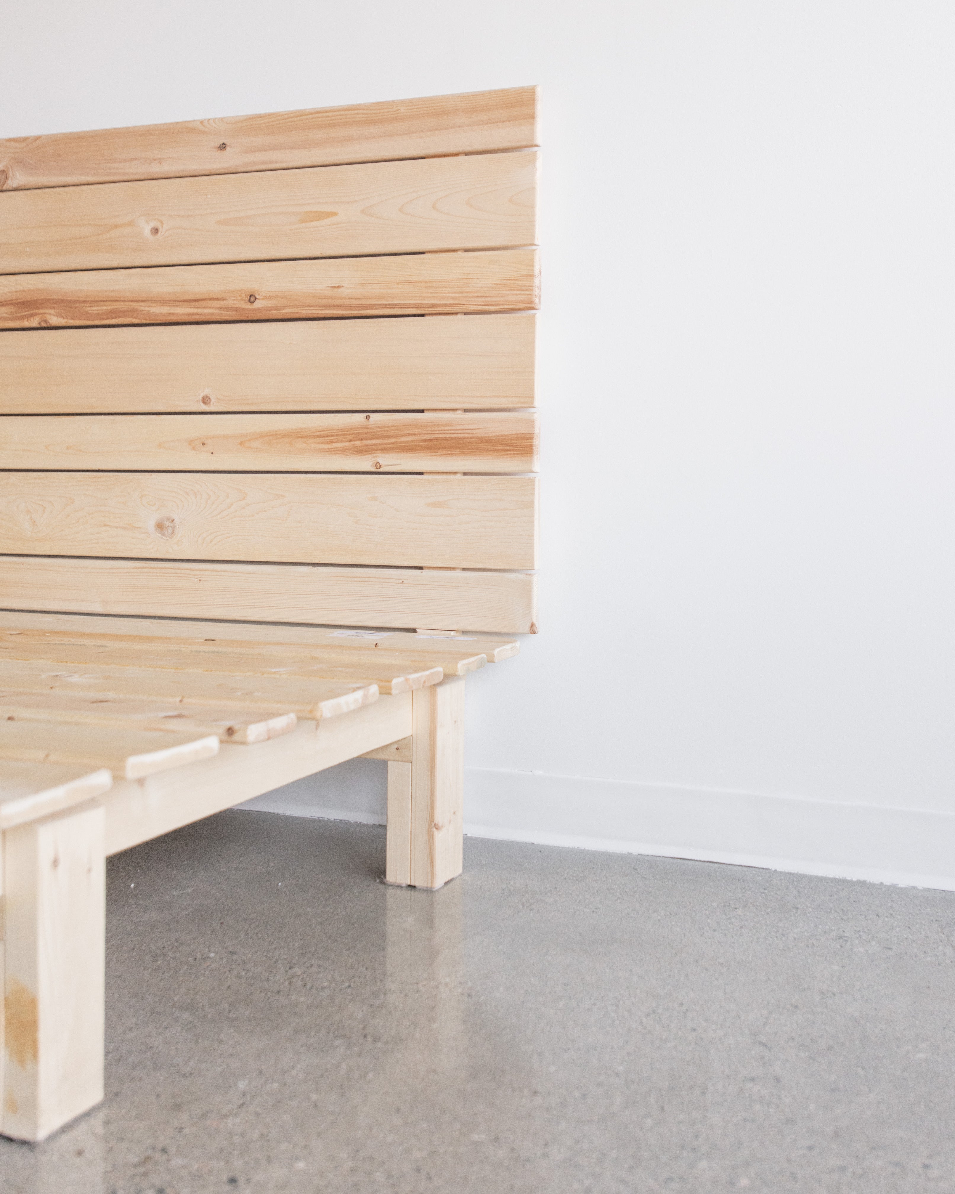 Magic Platform Bed Frame with natural wood slats spaced for optimized air flow and ventilation and a magic hedboard