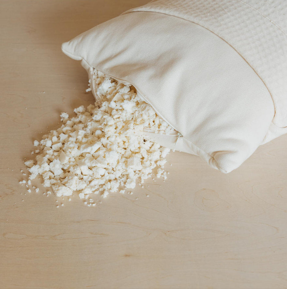 luxury organic pillow with shredded organic latex spilling out on a wooden surface