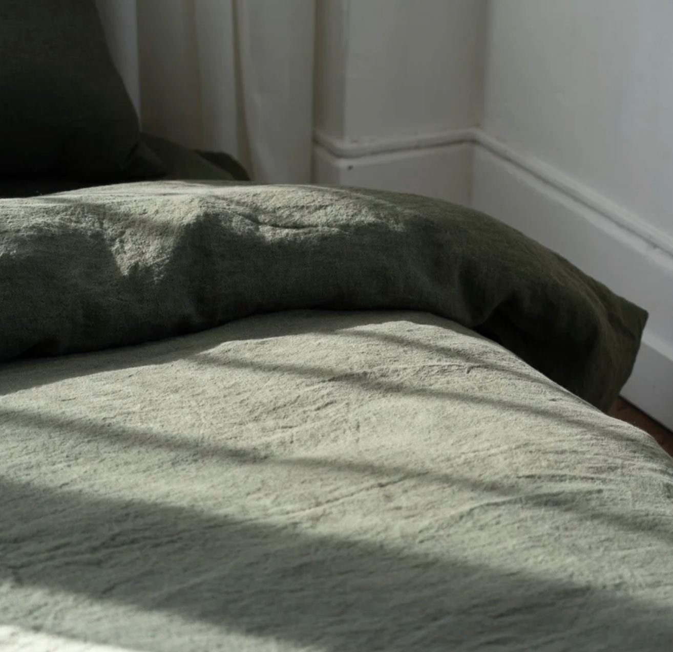 Somn Linen Sheets in Olive - close up of duvet cover natural light #colour_olive