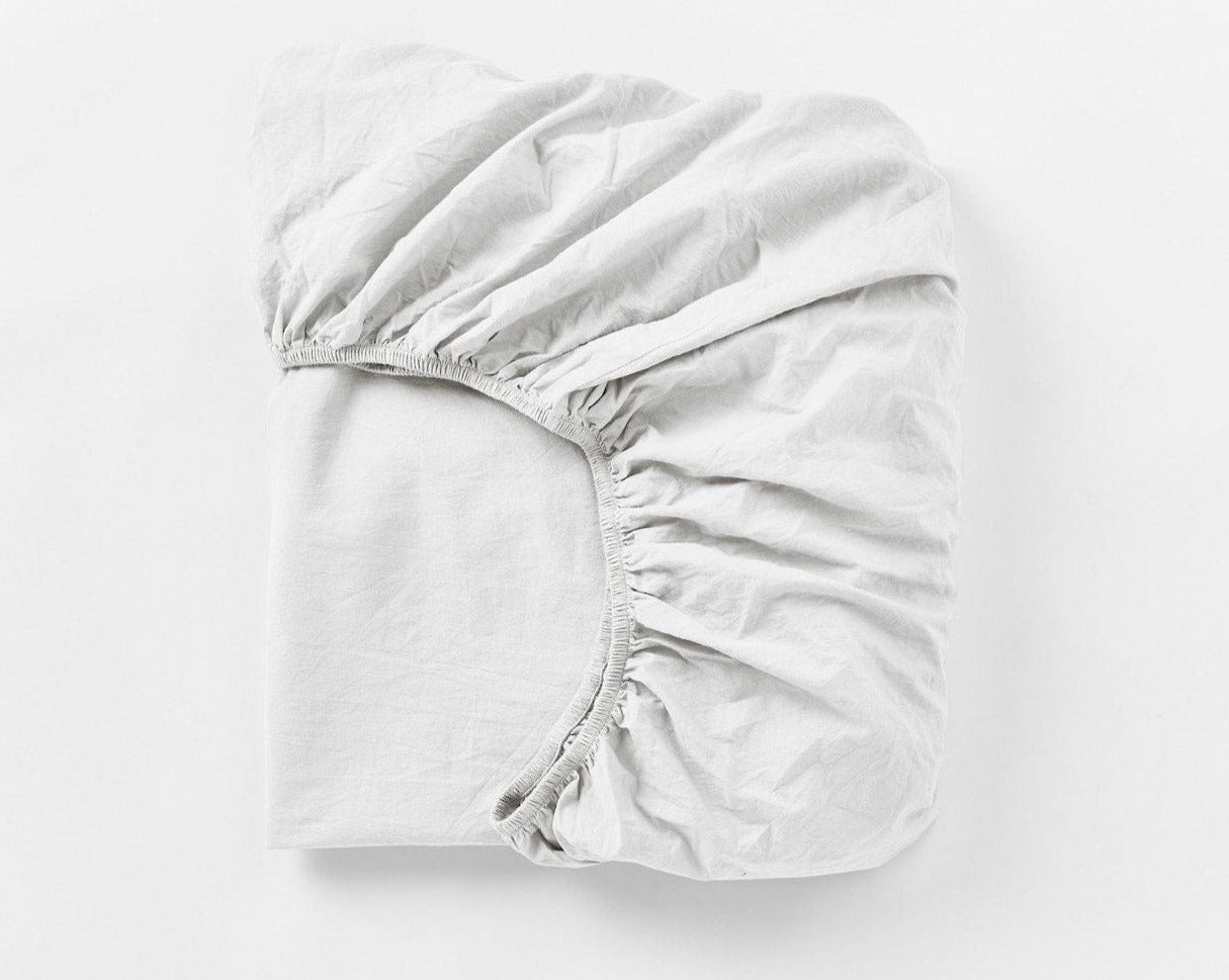Coyuchi Organic Crinkled Percale Fitted Sheet in Alpine White – folded to display elastic in seam. #colour_alpine white