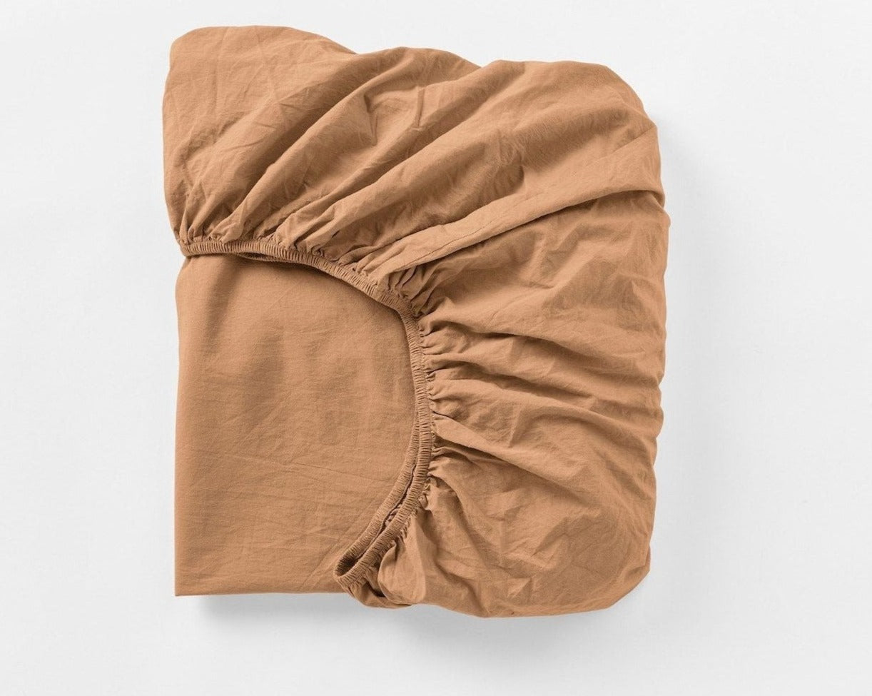 Coyuchi Organic Crinkled Percale Fitted Sheet in Ginger - folded to display elastic in seam. #colour_ginger