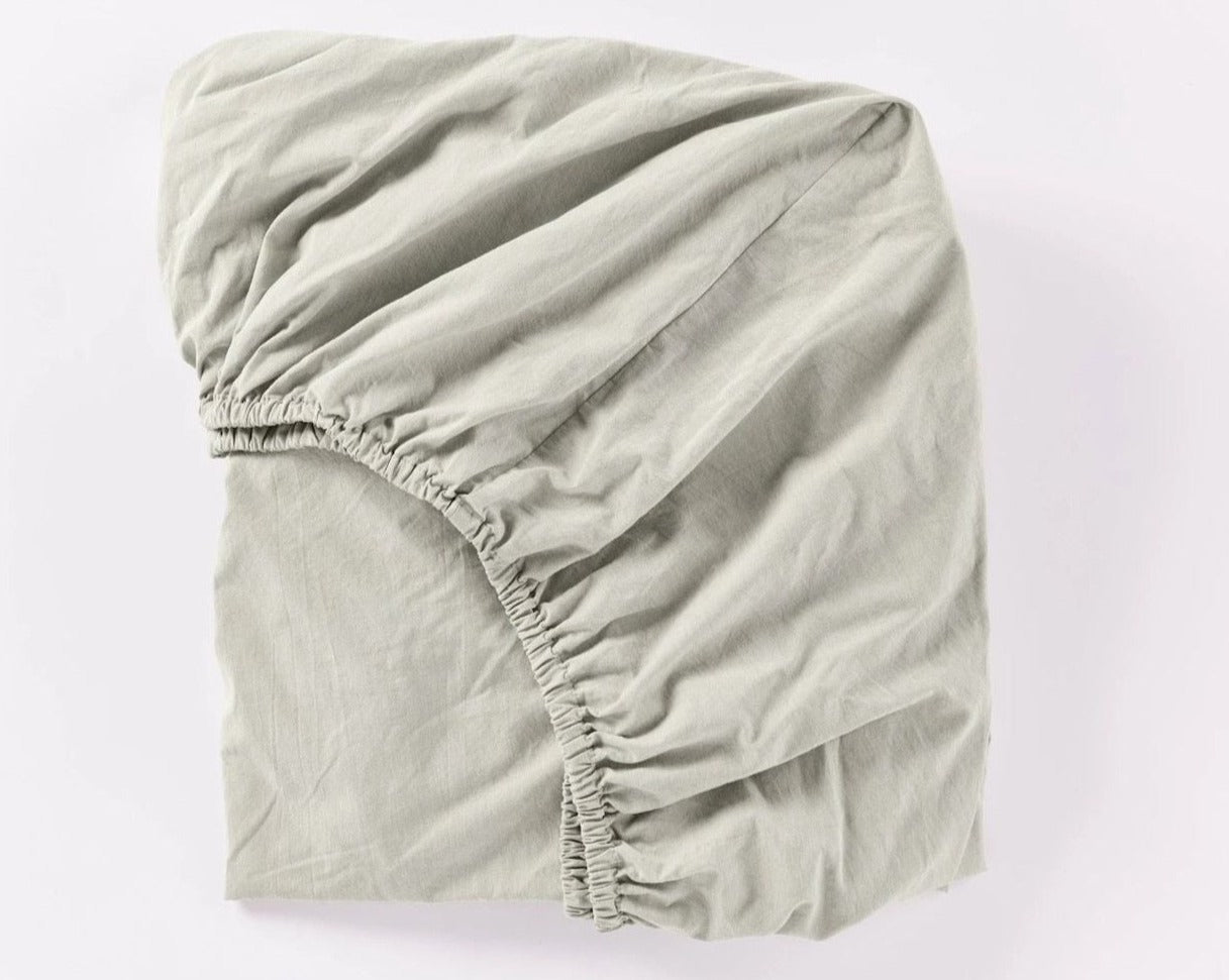 Coyuchi Organic Crinkled Percale Fitted Sheet in Laurel Chambray – folded to display elastic in seam. #colour_laurel chambray