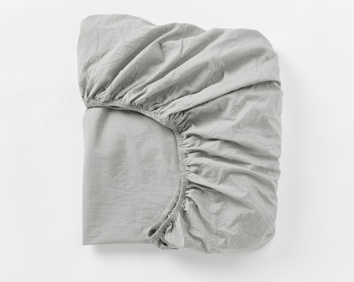 Coyuchi Organic Crinkled Percale Fitted Sheet in Pewter – folded to display elastic in seam. #colour_pewter