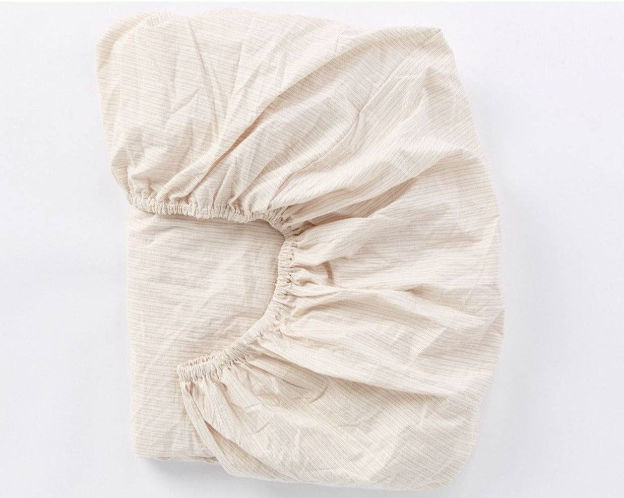 Coyuchi Organic Crinkled Percale Fitted Sheet in Undyed w/ Hazel Rosehip – folded to display elastic in seam. #colour_Undyed w/ Hazel Rosehip