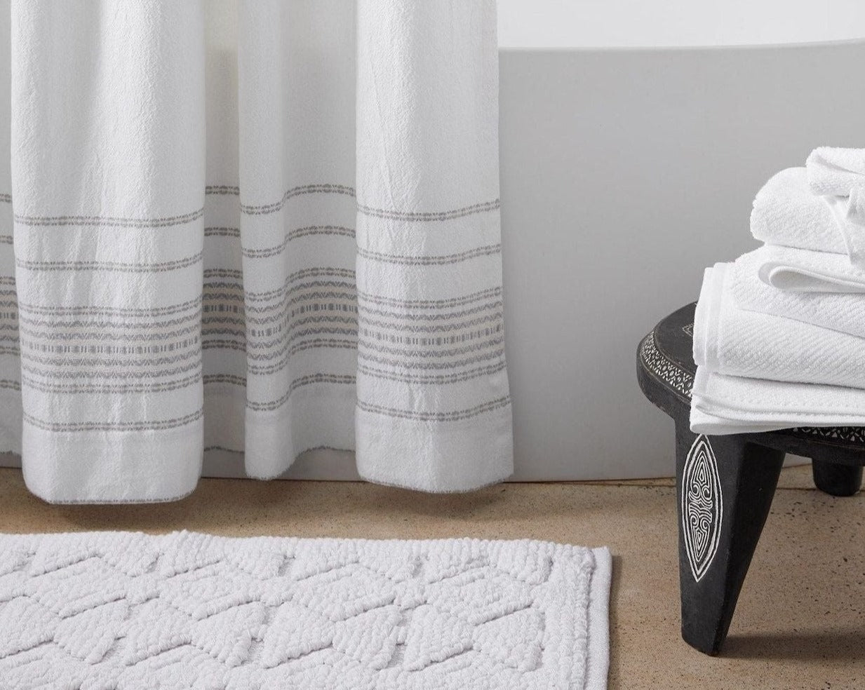 Coyuchi Organic Mosaic Canyon Bath Rug - on floor in front of tub beside stool with towels #colour_Alpine White w/ Fog