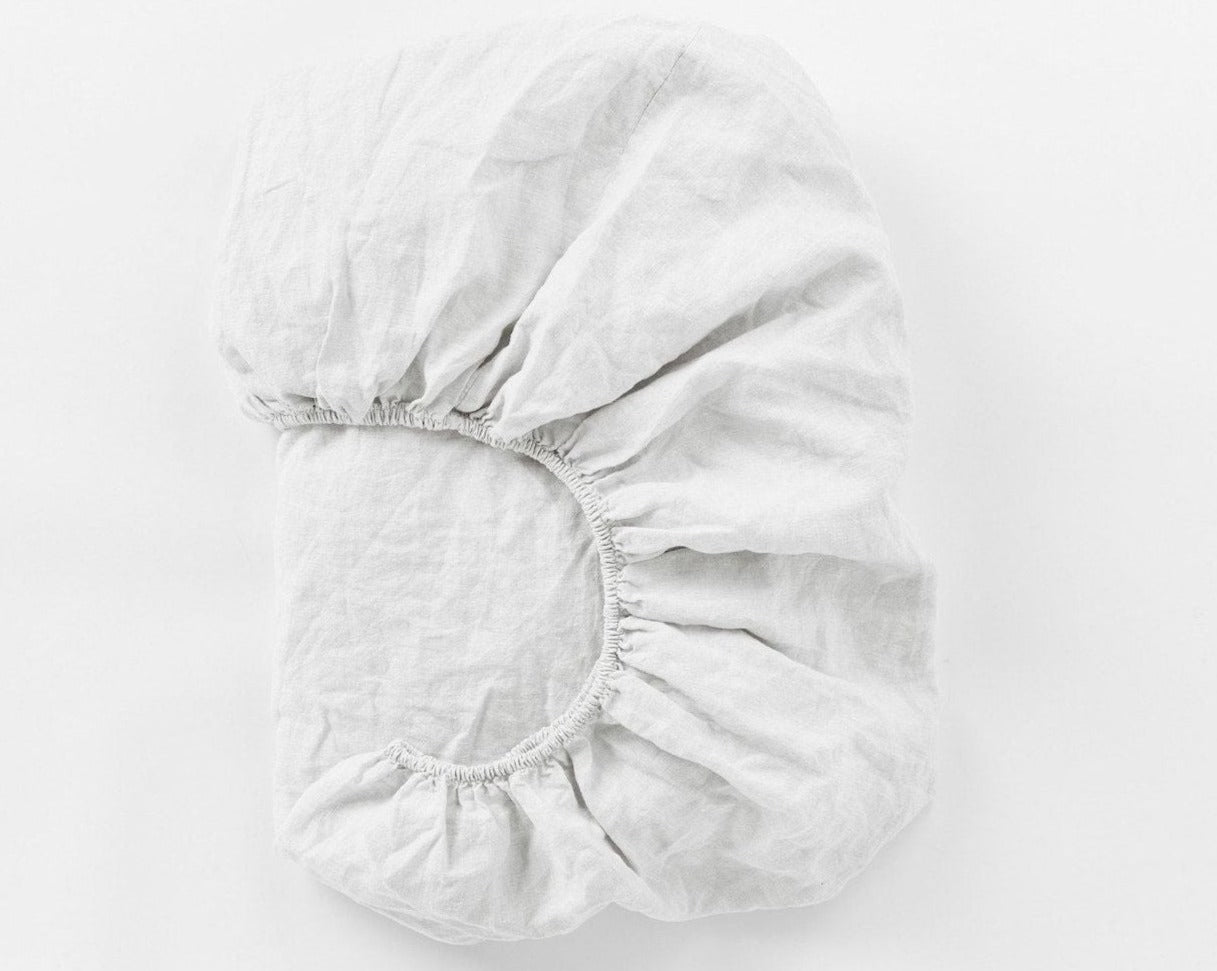 Coyuchi Organic Relaxed Linen Fitted Sheet in Alpine White – folded to display elastic in seam. #colour_alpine white
