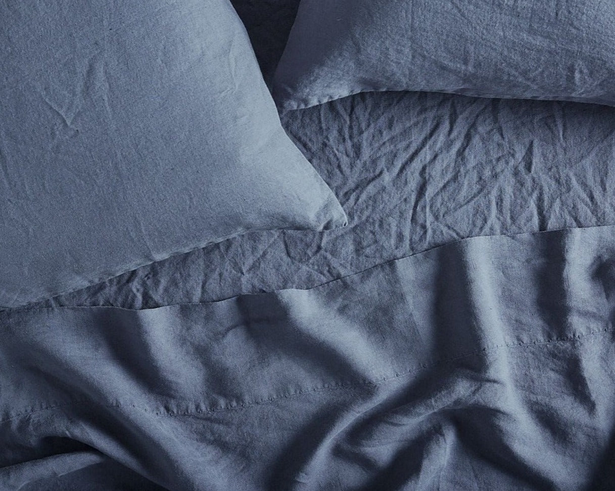 Coyuchi Organic Relaxed Linen Fitted Sheet in Harbor Blue – close-up shot of weave quality and details of stitching. #colour_Harbor Blue