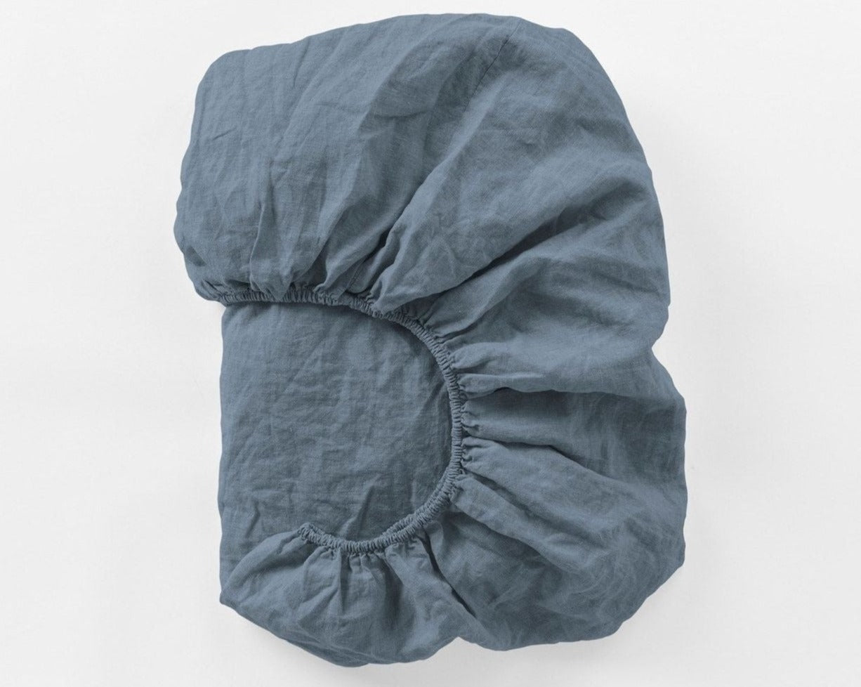 Coyuchi Organic Relaxed Linen Fitted Sheet in Harbor Blue – folded to display elastic in seam. #colour_Harbor Blue