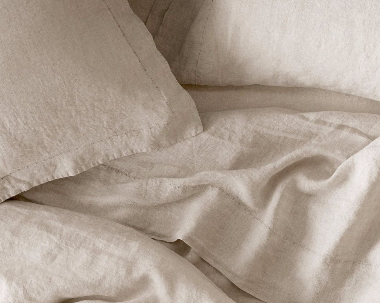 Coyuchi Organic Relaxed Linen Fitted Sheet in Natural Chambray – close up highlighting stitching on pillowcases and flat sheet. #colour_Natural Chambray