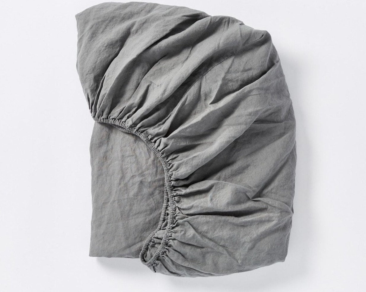Coyuchi Organic Relaxed Linen Fitted Sheet in Slate – folded to display elastic in seam. #colour_Slate