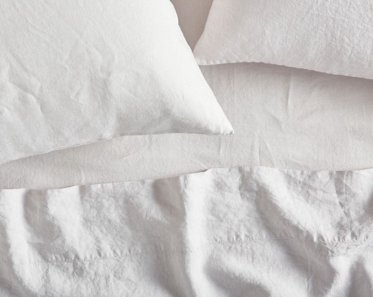 Coyuchi Organic Relaxed Linen Pillowcases in Alpine White – close-up view of linen texture and stitching details. #colour_alpine white