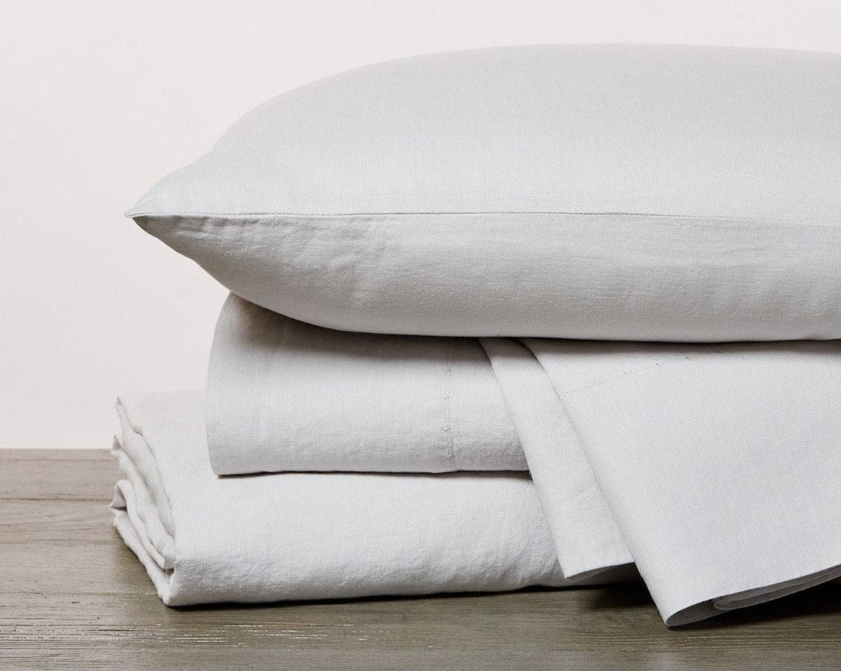 Coyuchi Organic Relaxed Linen Pillowcases in Fog – stack display showing sheets and pillowcase linen texture. #colour_fog