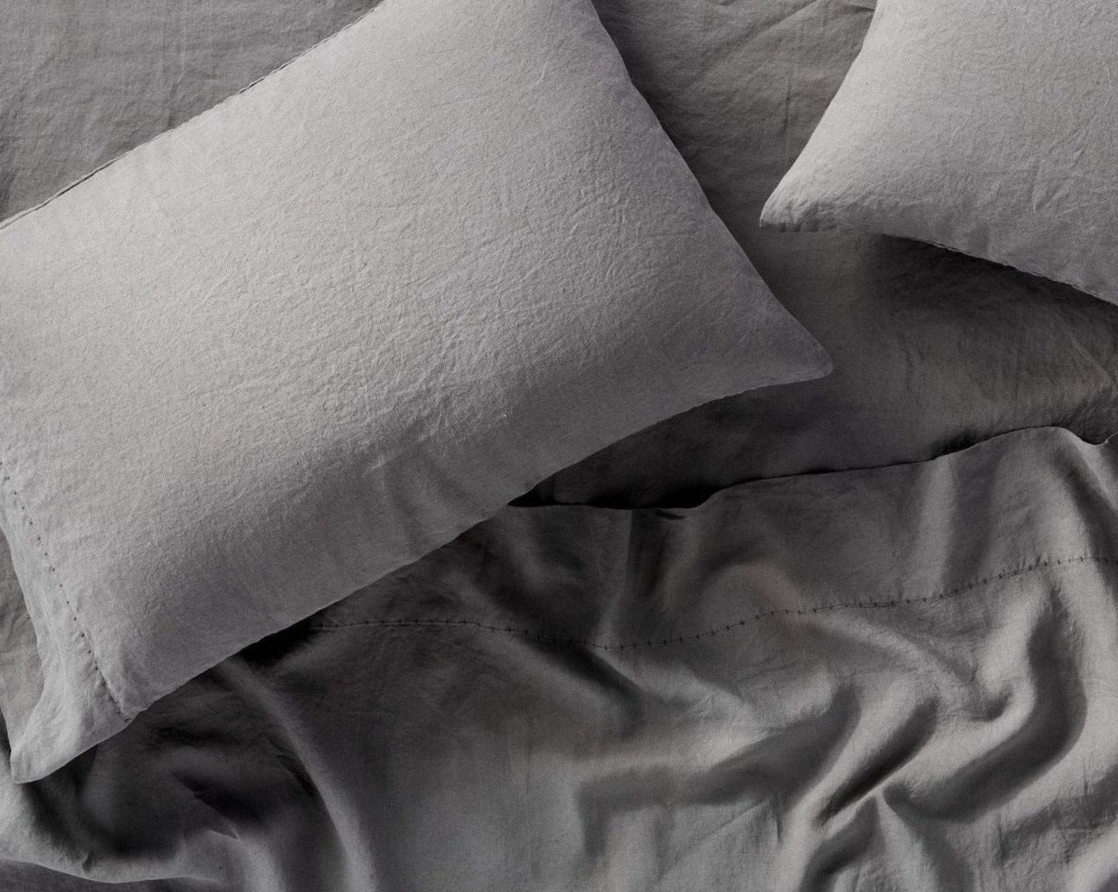 Coyuchi Organic Relaxed Linen Pillowcases in Slate – close-up of linen texture and stitching details. #colour_slate