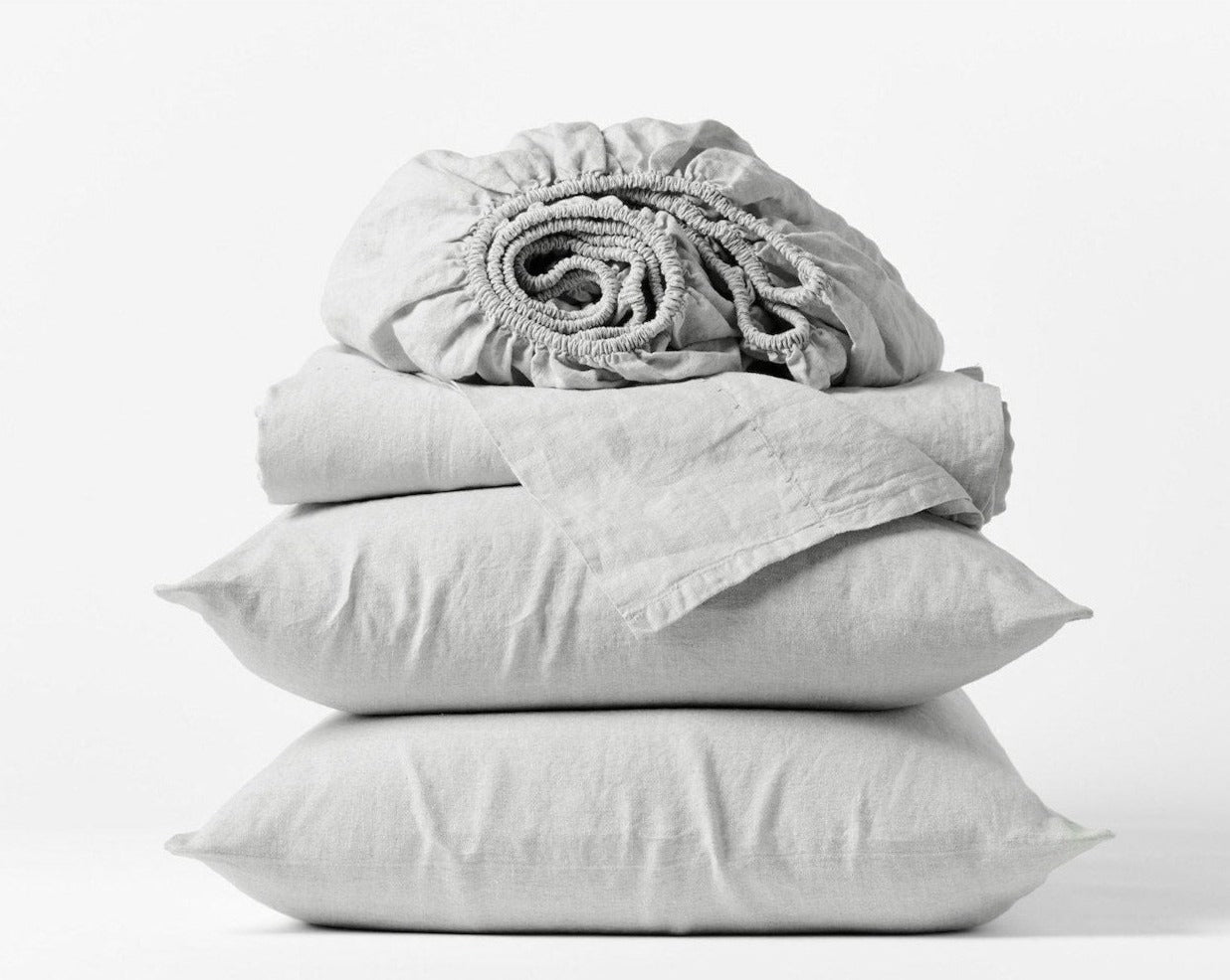Coyuchi Organic Relaxed Linen Sheet Set in Fog – stacked display with pillows and folded sheets. #colour_fog
