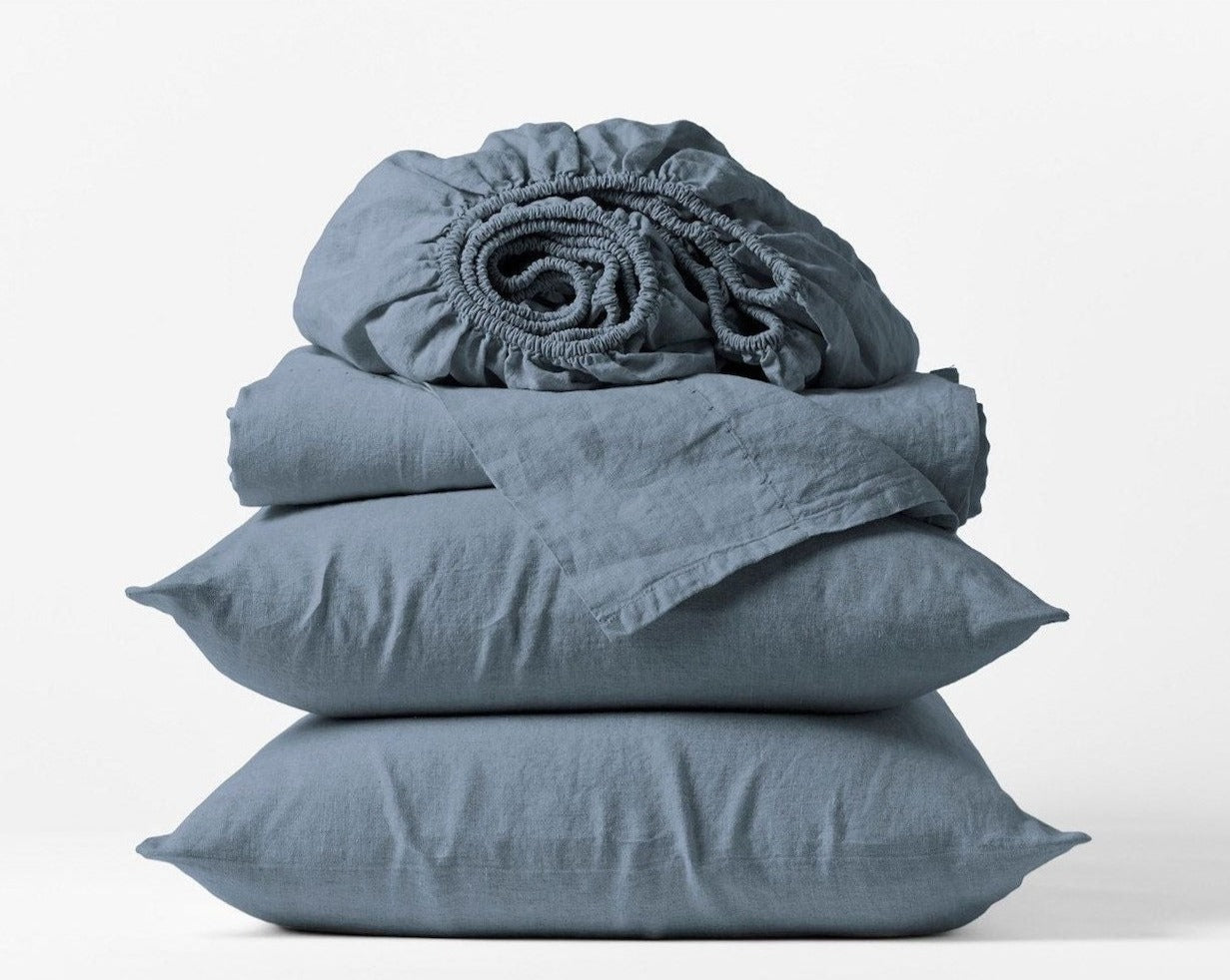 Coyuchi Organic Relaxed Linen Sheet Set in Harbor Blue – stacked display with pillows and folded sheets. #colour_harbor blue