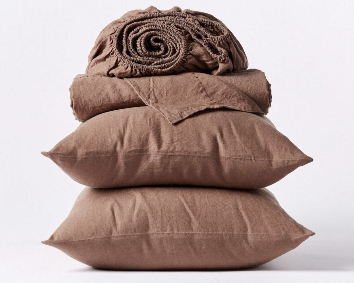 Coyuchi Organic Relaxed Linen Sheet Set in Redwood – stacked display with pillows and folded sheets. #colour_redwood
