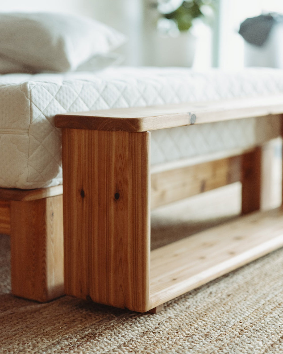 Adrift Cedar Crest Bench - corner shot with natural light in front of matching bed frame