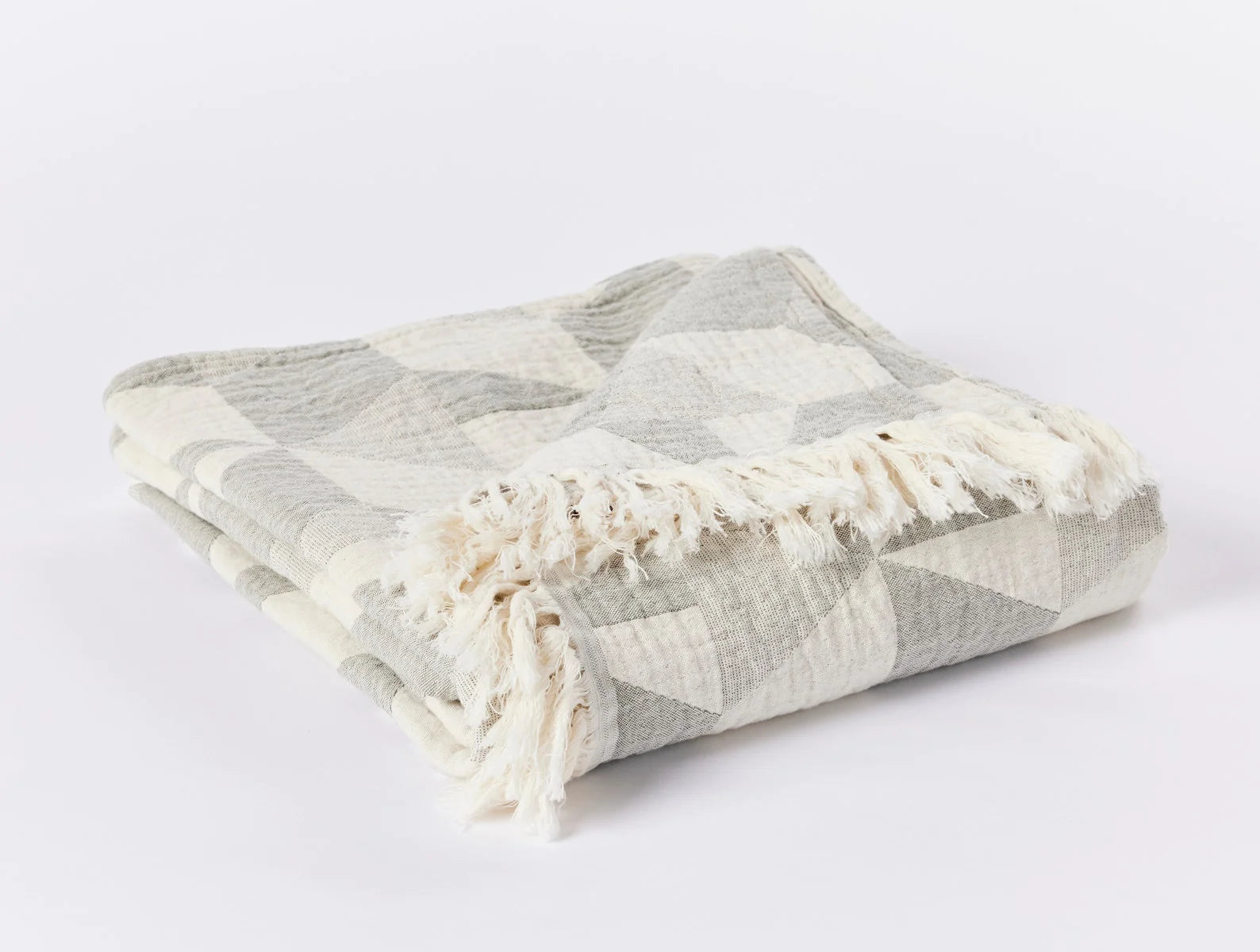 Pismo Organic Cotton Throw in Cypress folded to show off the 2.5" fringe on the top and bottom. Bright, white background.