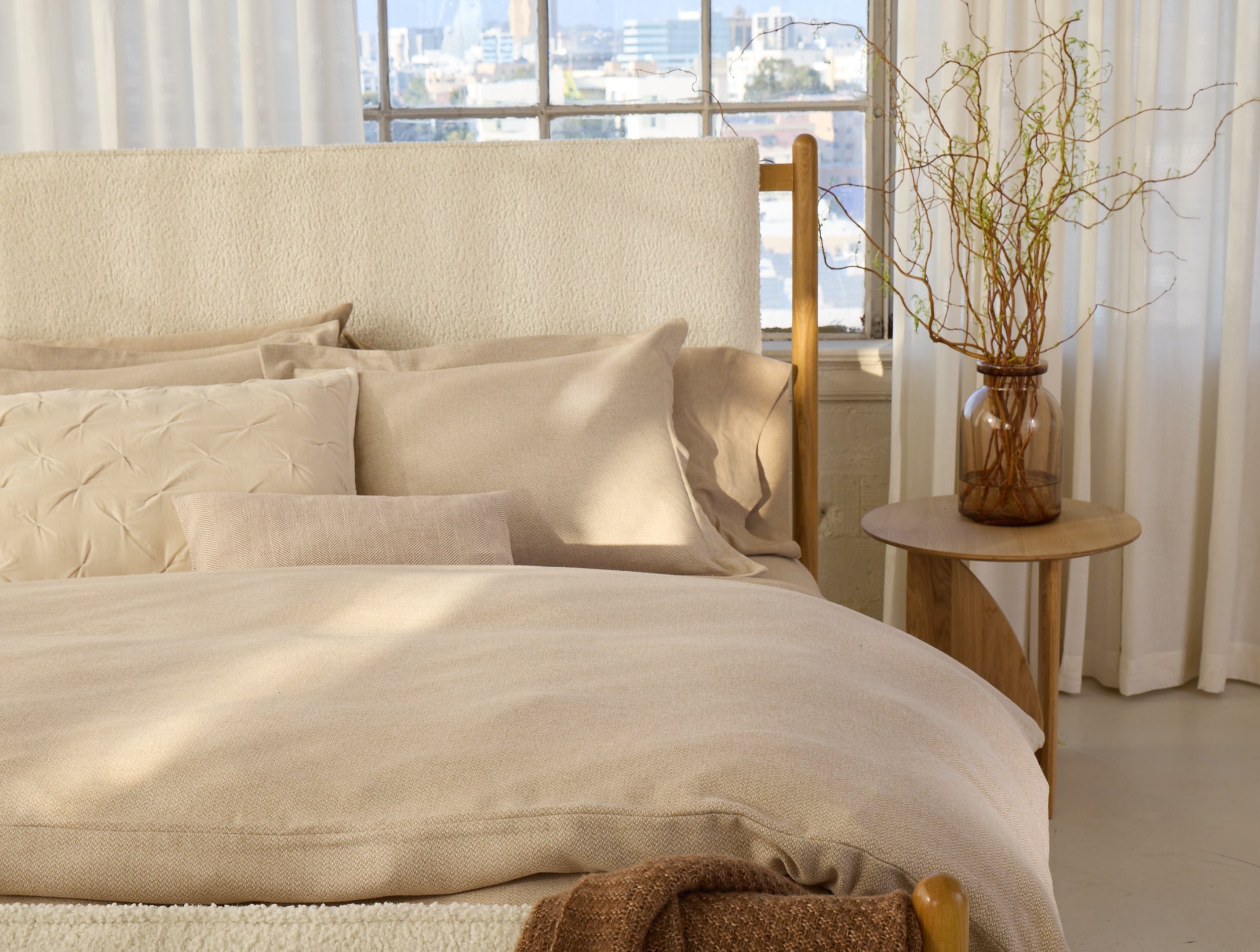 Coyuchi Cloud Brushed Organic Flannel Texture Duvet Cover - staged bed with plant on side table #colour_camel heather