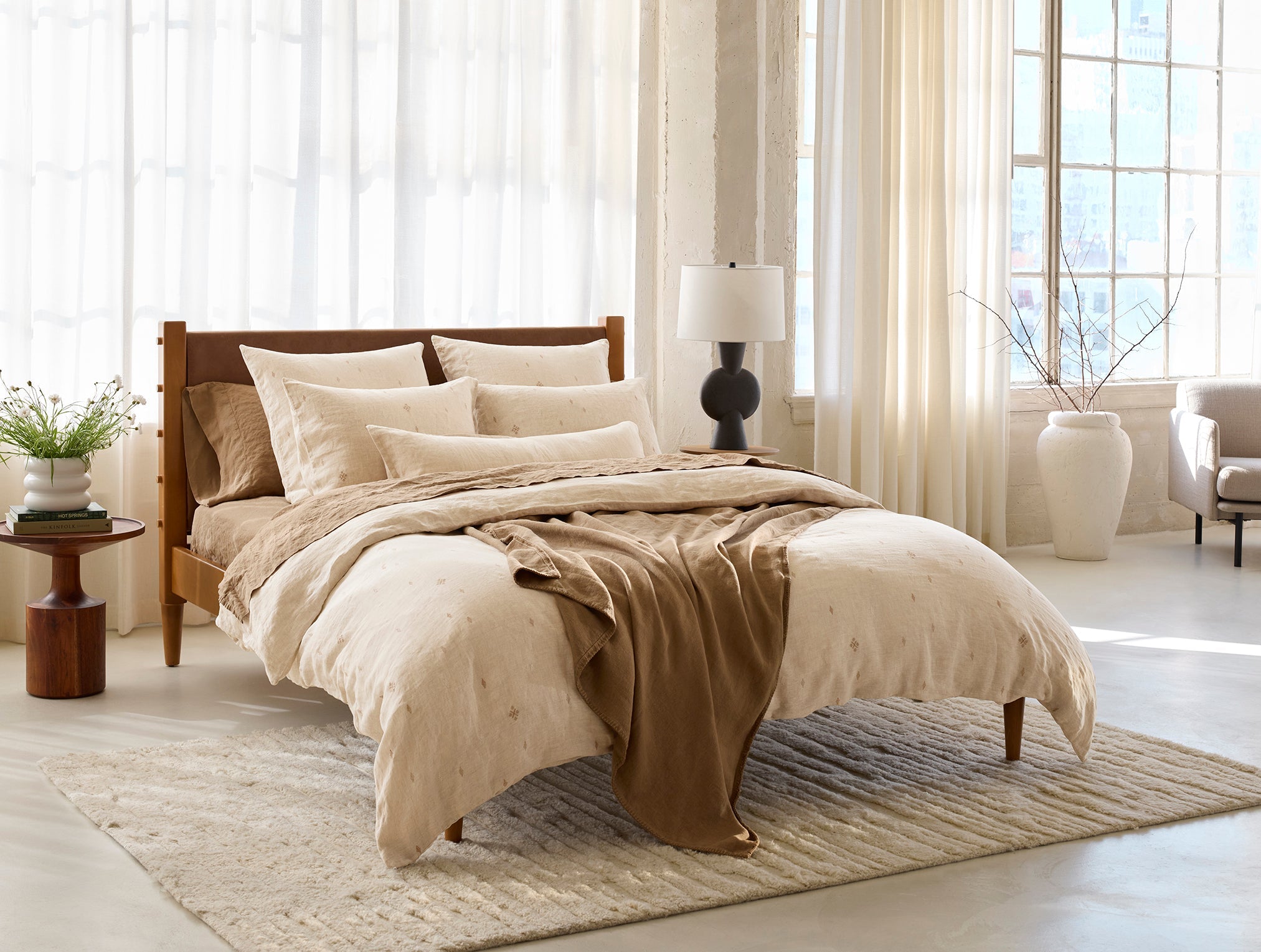 Coyuchi Helena Organic Linen Blanket - draped over staged bed wood frame #colour_doe