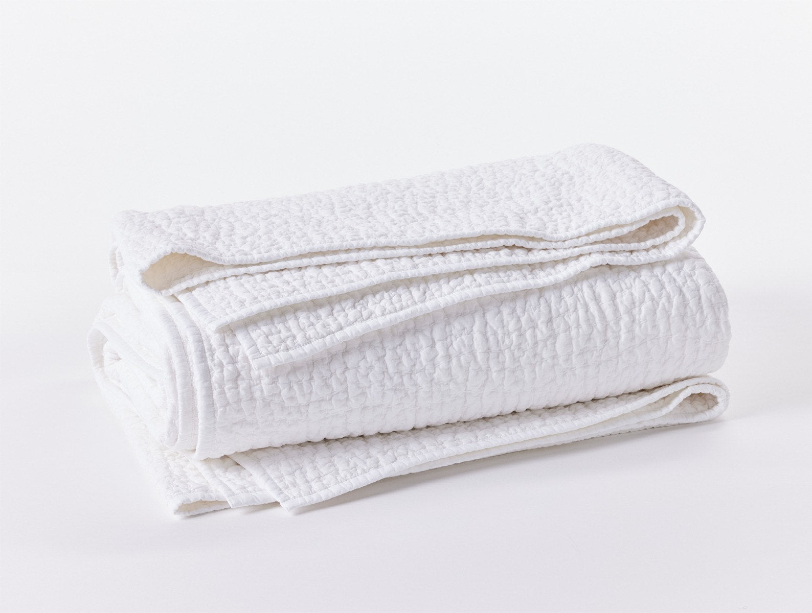 Coyuchi Organic Pebbled Hand Stitched Quilt - folded #colour_alpine white