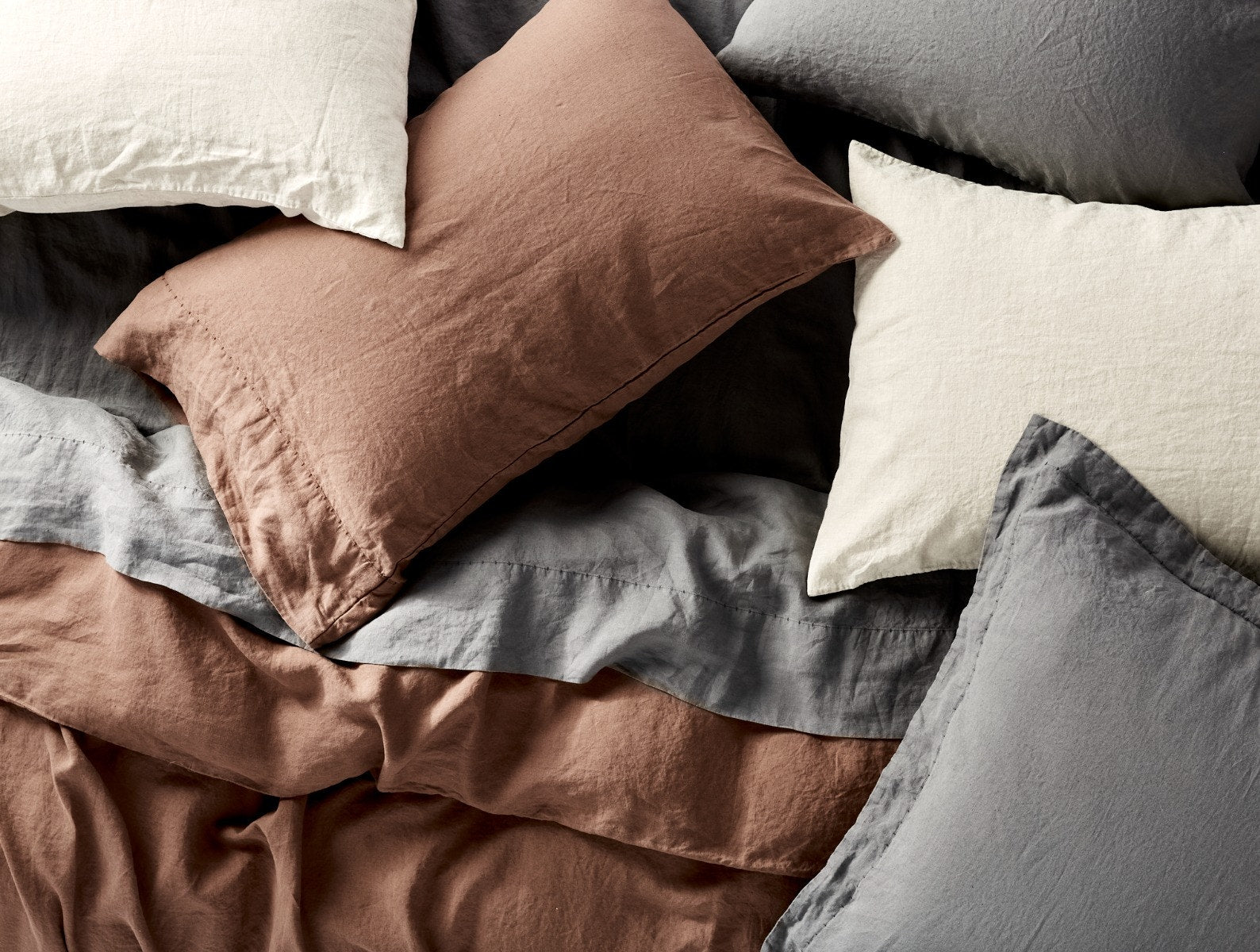 Coyuchi Organic Relaxed Linen Duvet Cover - many pillows various colours on bed #colour_slate