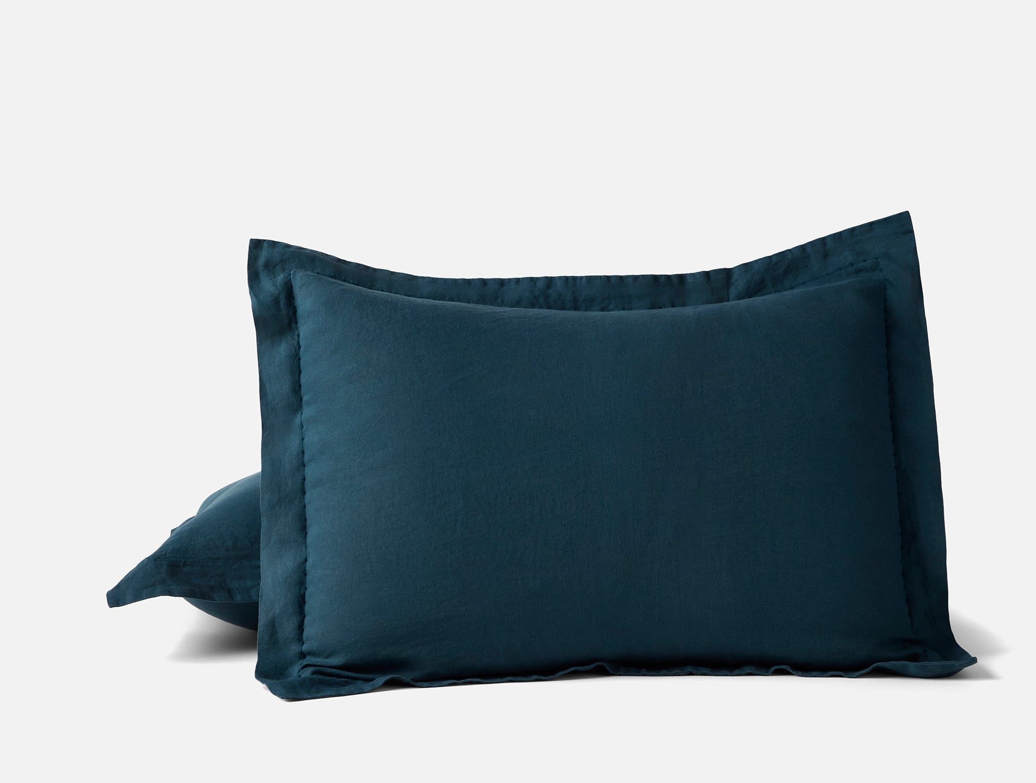 Coyuchi organic relaxed linen pillow sham - propped up on white background #colour_midnight indigo