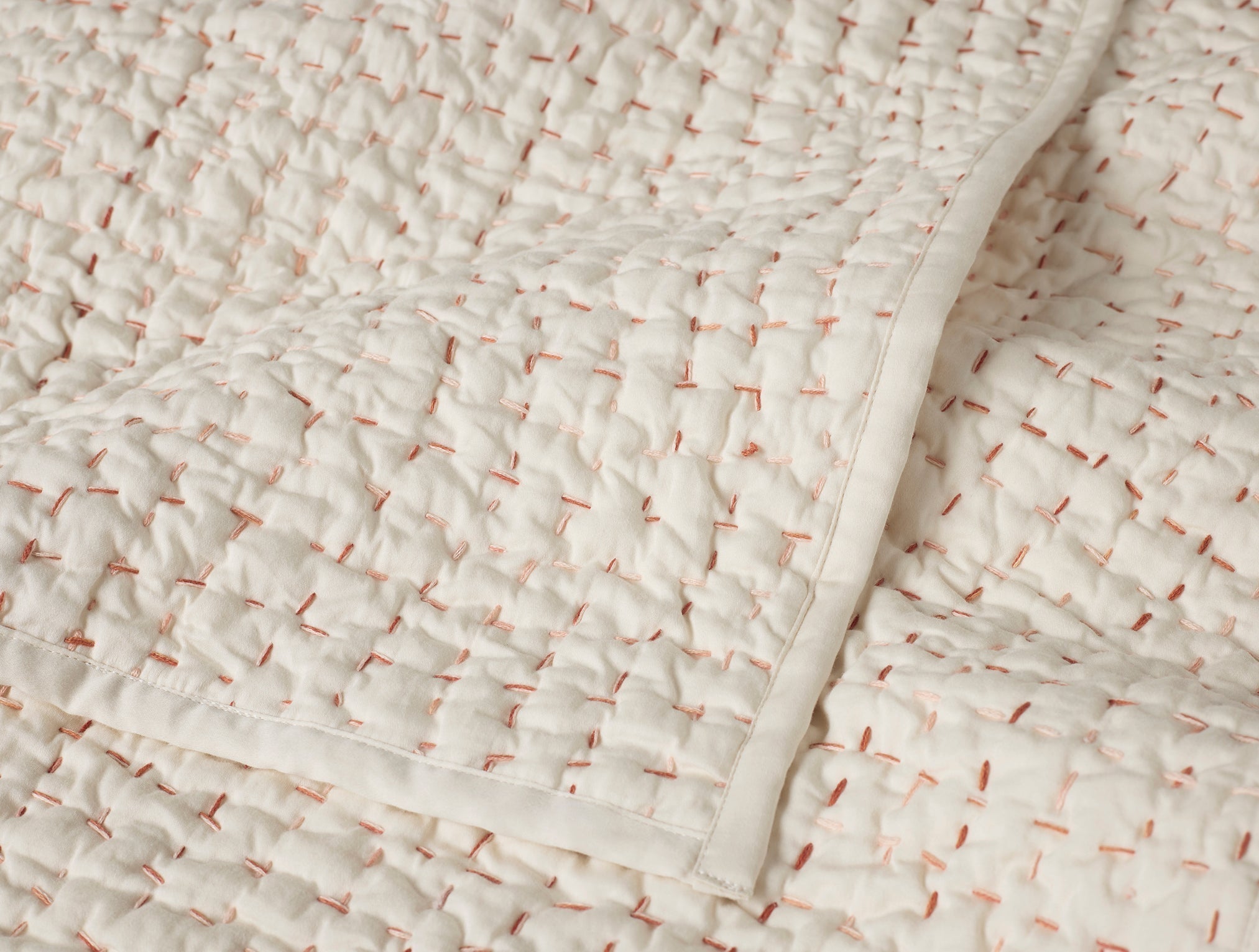Coyuchi Pebbled Hand Stitched Organic Cotton Toddler Quilt in Undyed with Warms - close up #colour_undyed w/ warms