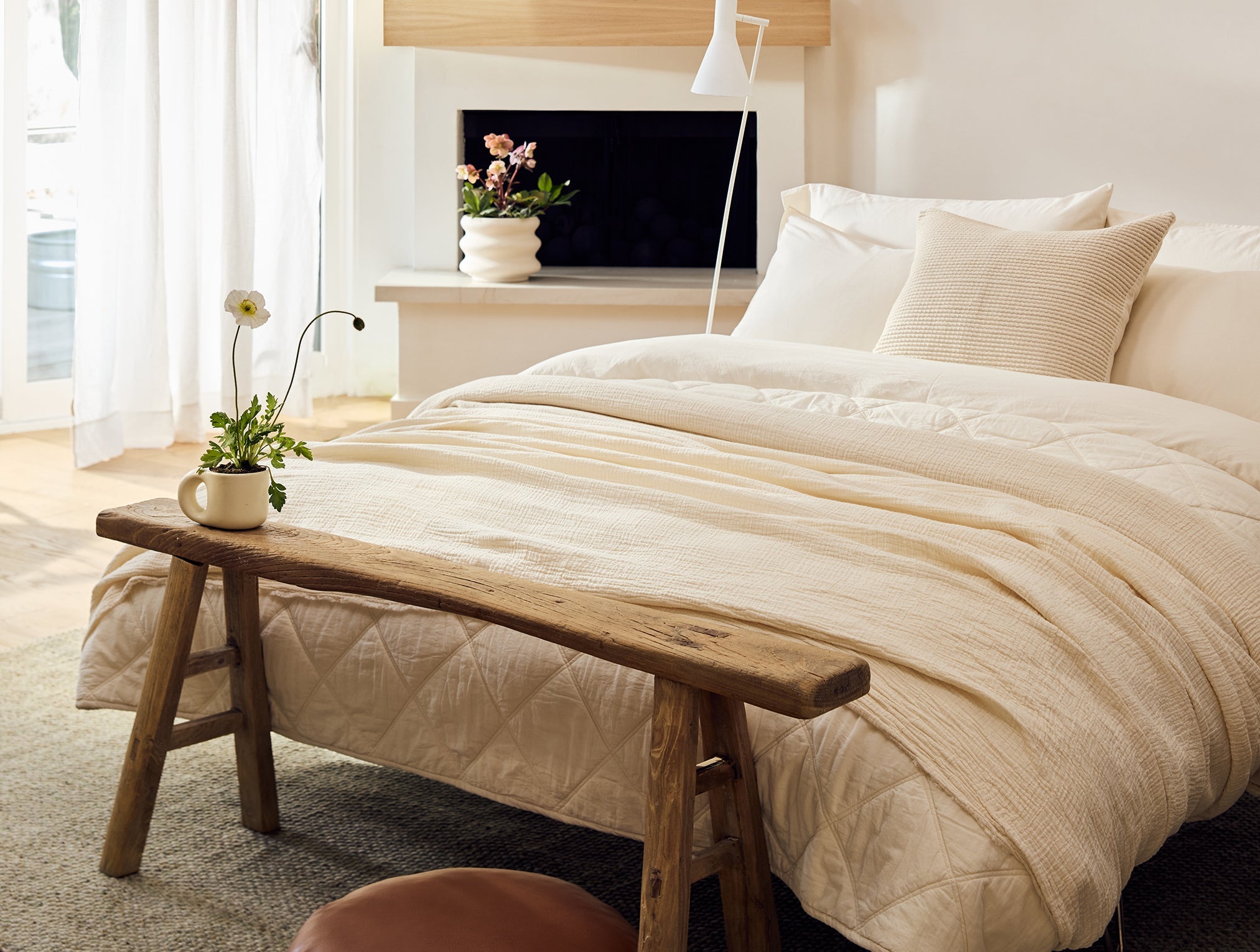 Coyuchi Topanga Organic Matelasse Blanket - staged room wood bench at foot of bed #colour_undyed