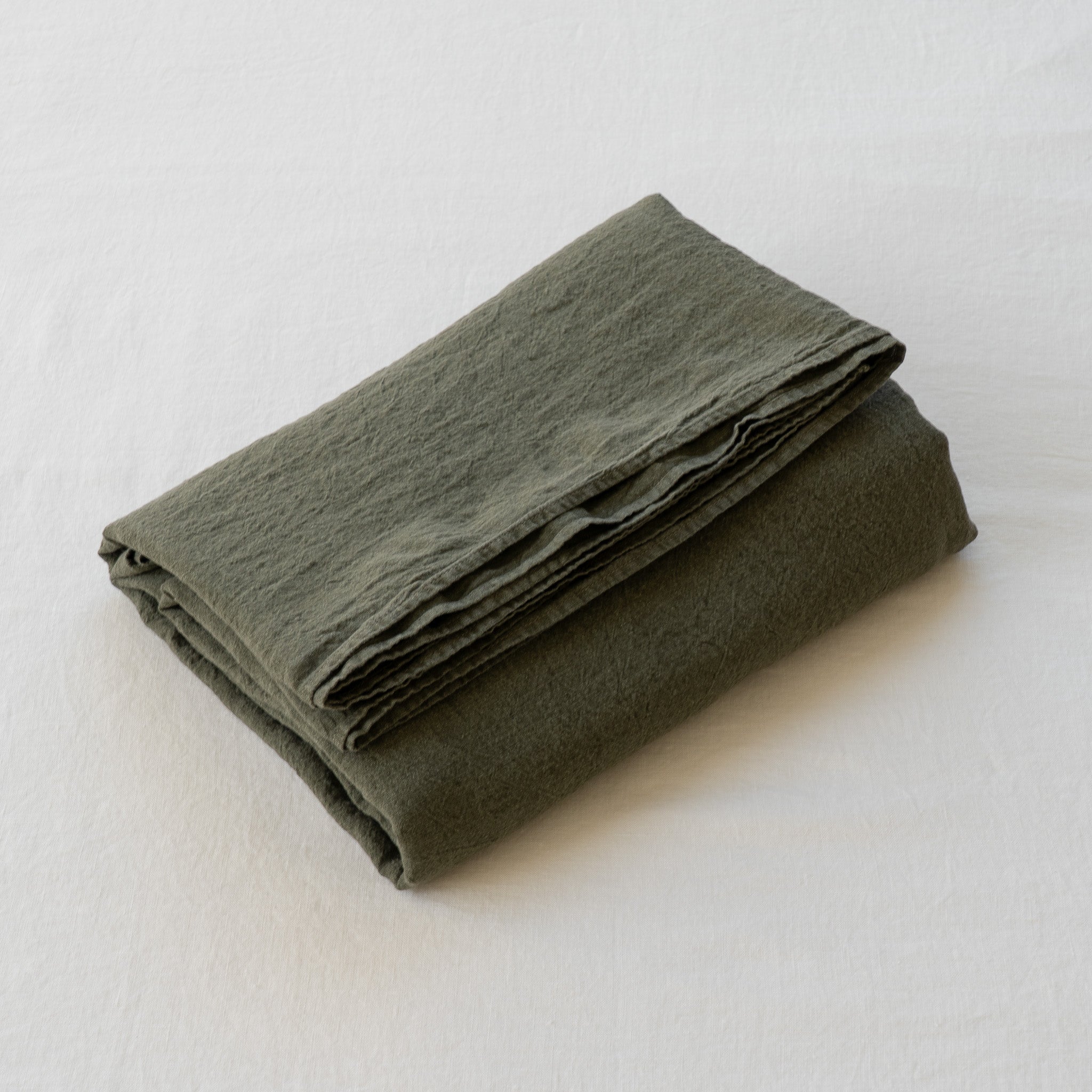 Somn European Linen Flat Sheet in Olive - folded white background #colour_olive