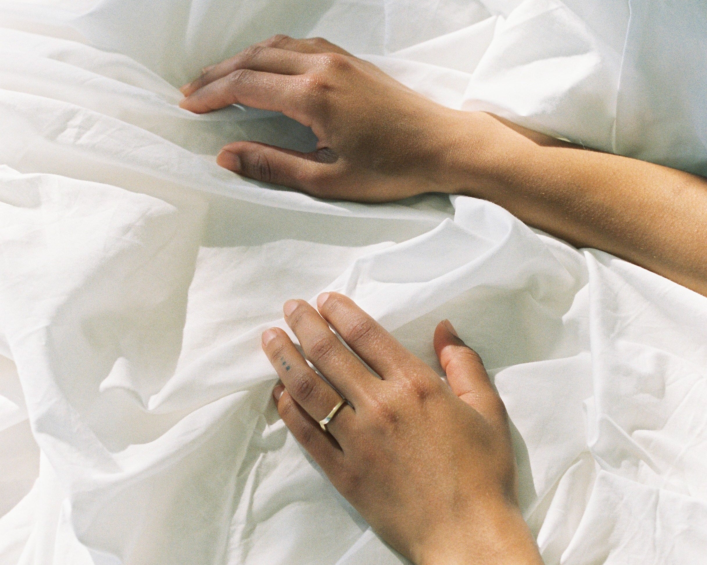 Close-up of hands smoothing white fabric