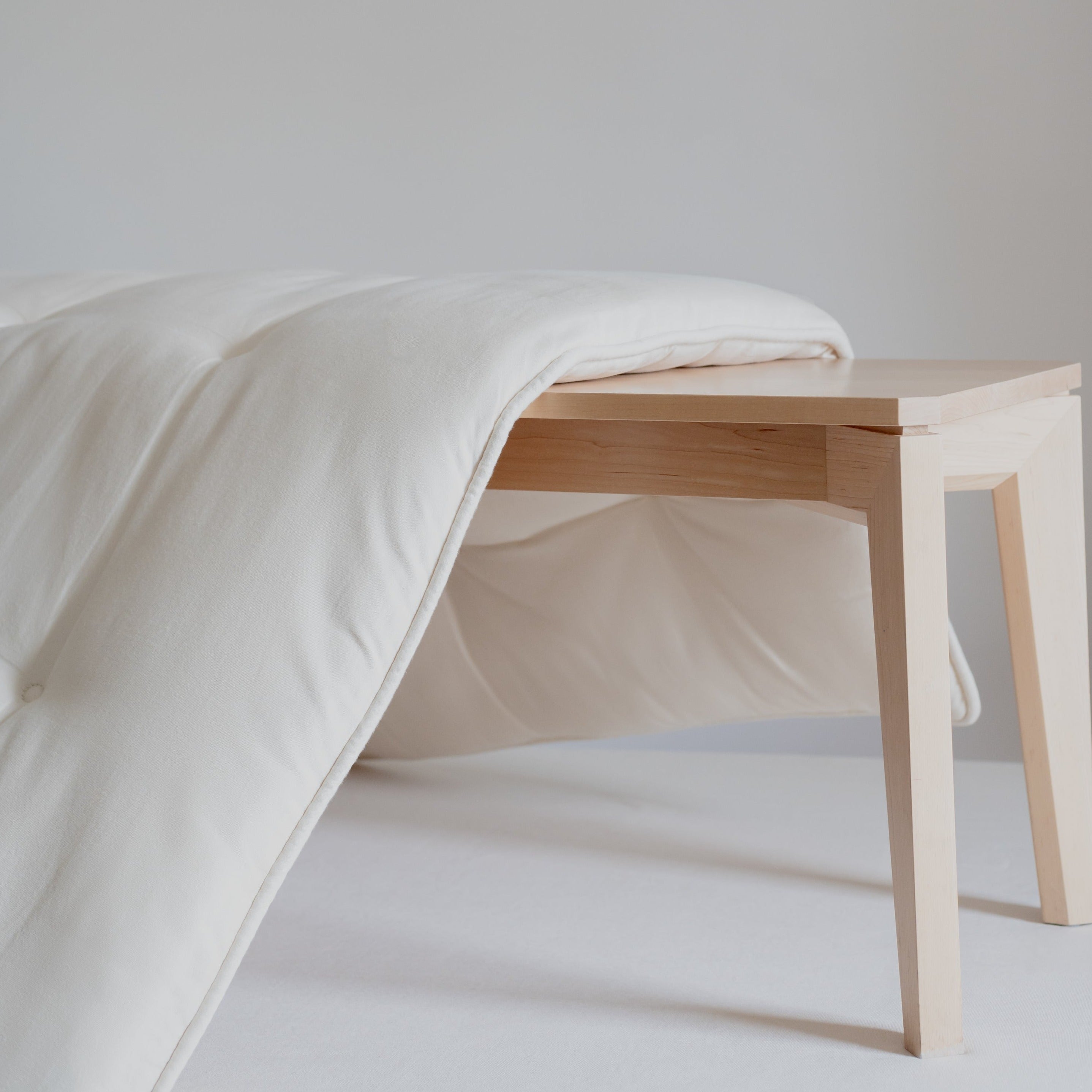 Obasan Deluxe Organic Mattress Topper - draped over natural wood bench