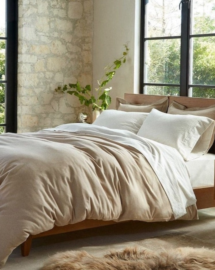 Coyuchi Organic Cloud Brushed Flannel Duvet Cover - staged bed large windows side table plant #colour_camel heather
