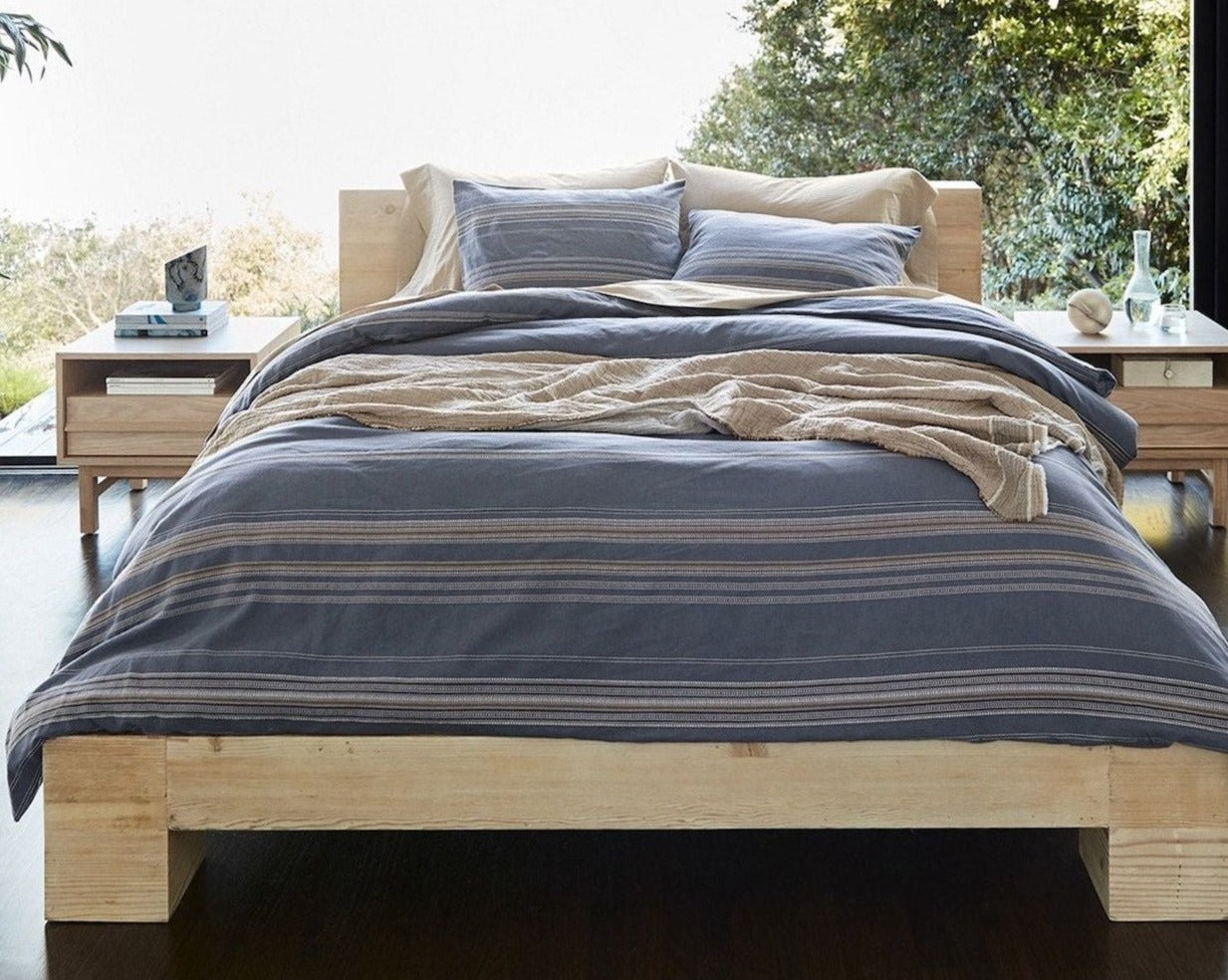 Coyuchi Organic Lobos Duvet Cover - staged bed wood frame large window behind #colour_Azure w/ Indigo