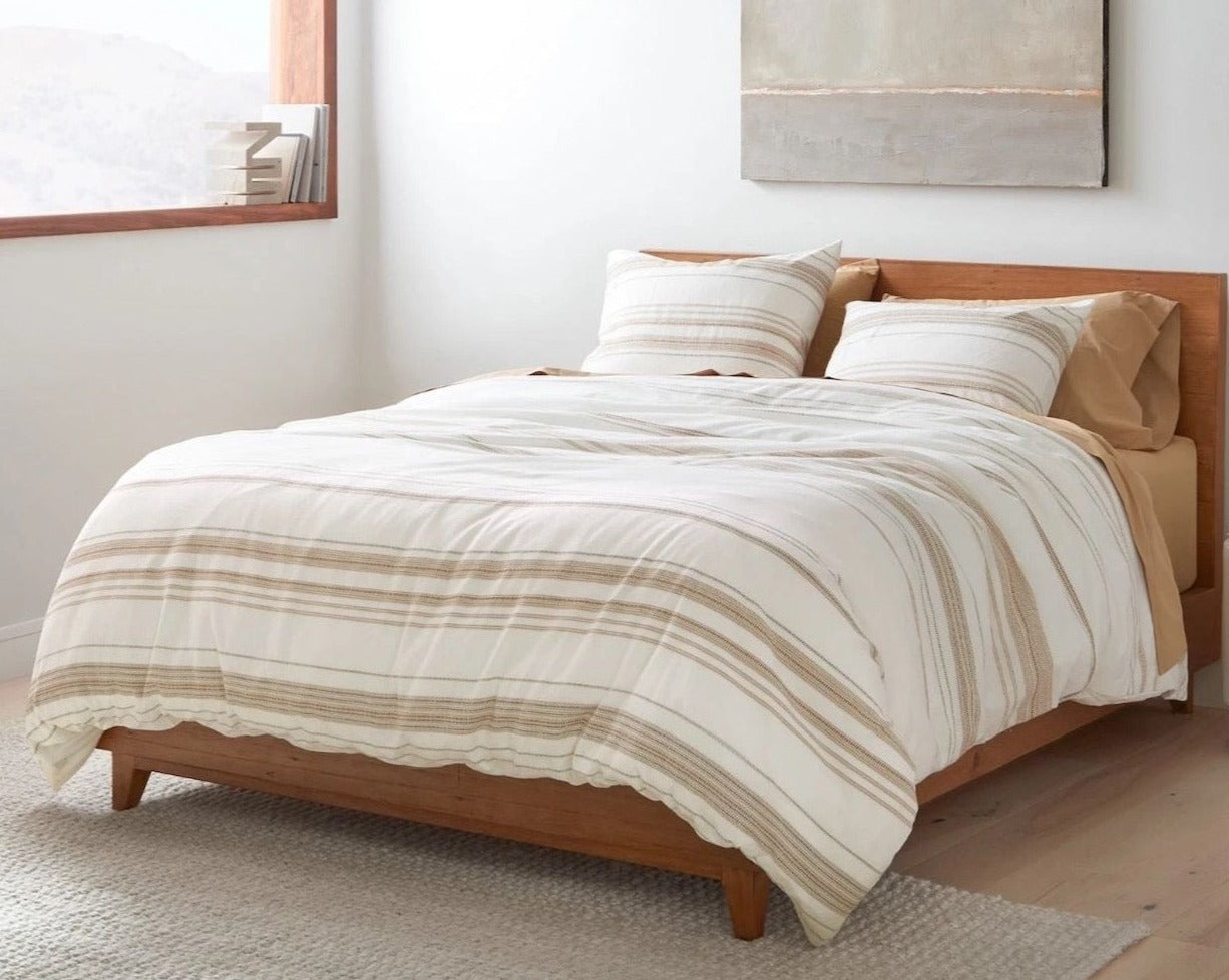 Coyuchi Organic Lobos Duvet Cover - staged bed with wood frame natural lighting #colour_Soft White w/ Hazel