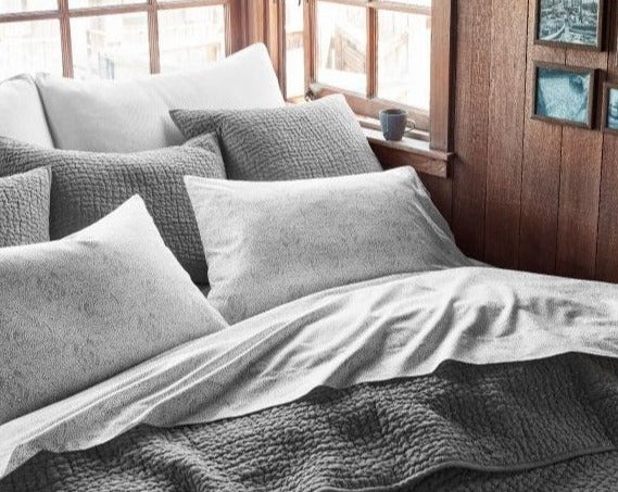 Coyuchi Organic Pebbled Hand Stitched Quilt - staged bed with many pillows #colour_slate