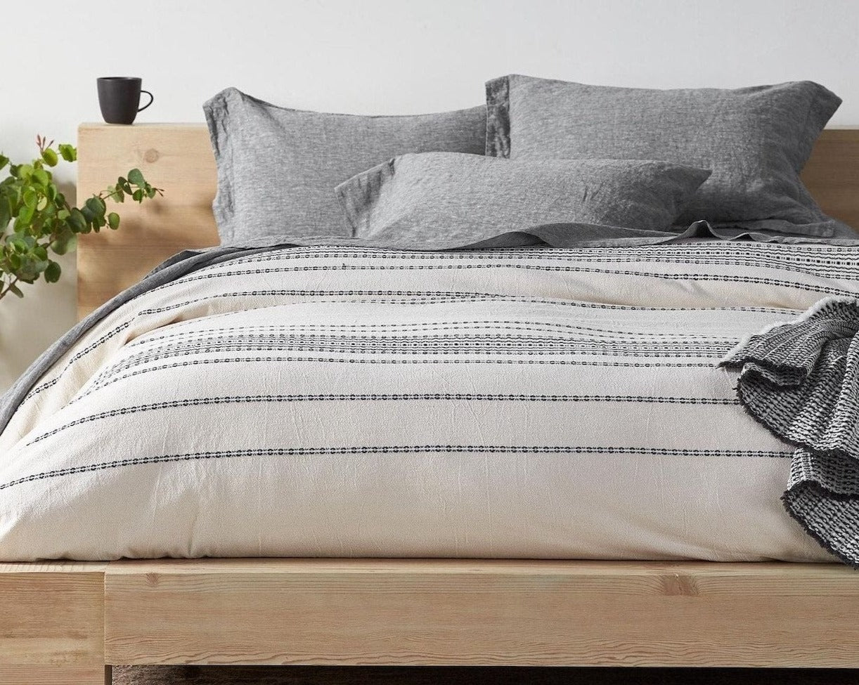 Coyuchi Organic Rippled Stripe Duvet Cover - staged bed with wood frame #colour_ivory w/ black