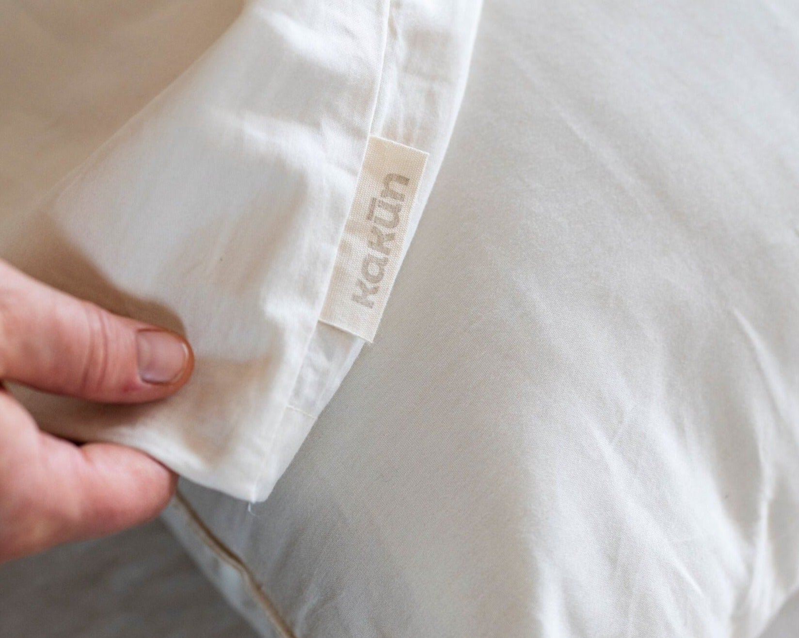 Kakun Organic Cotton Sateen Body Pillow Case - close up of tag being held in hand
